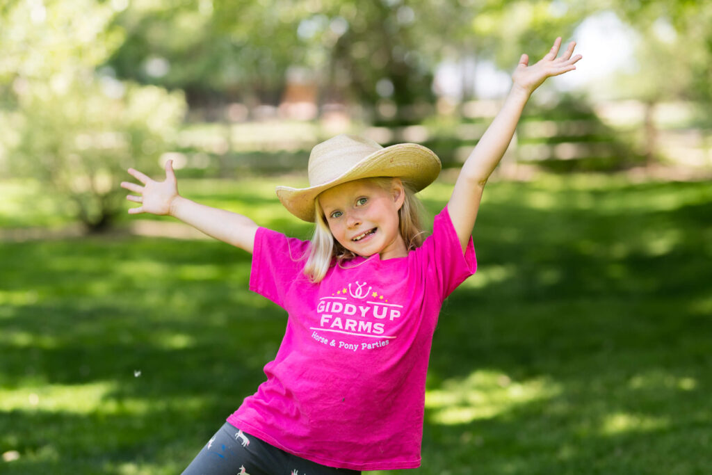 Girl in cowboy hat and Giddyup Farms t-shirt